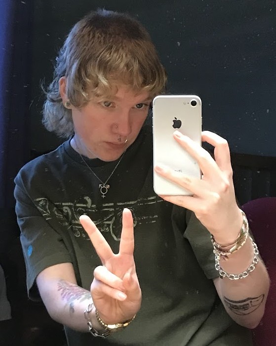 man with dirty blond medium length hair a green tee