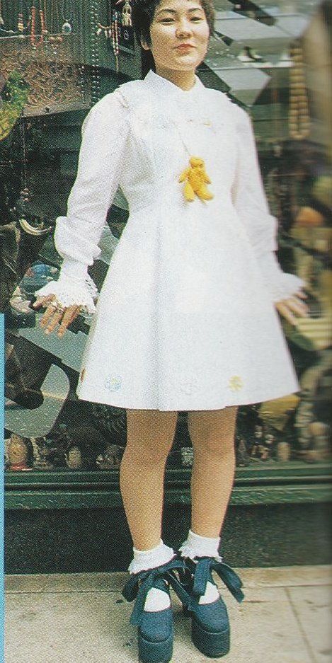 A Lolita in all white with black platform heels