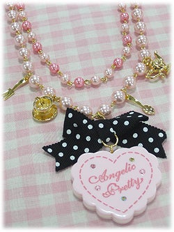 Light pink heart shaped necklace with black and white ribbon